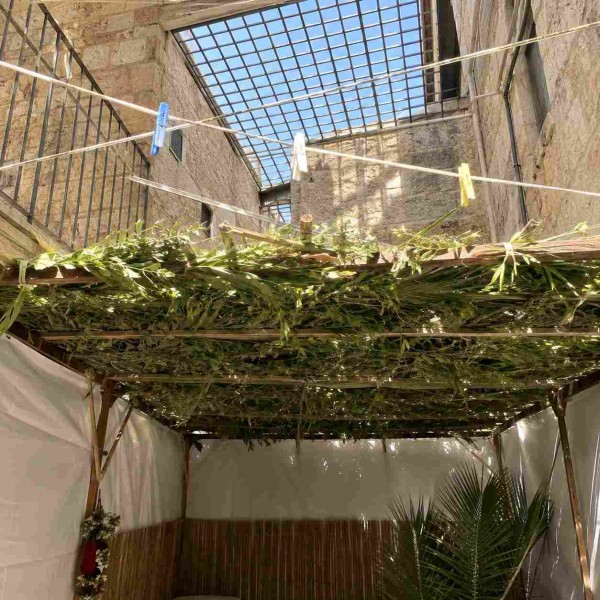 סוכה שתחת חלון מסורג בתקרה ושתחת חבלי כביסה